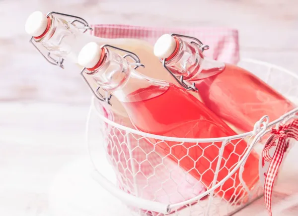 bottles in a basket filled with pink beverage