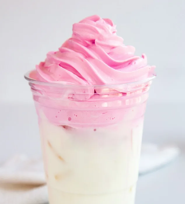 pink whipped cream over iced drink